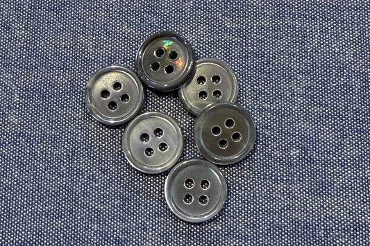 Grey buttons on a blue denim fabric background
