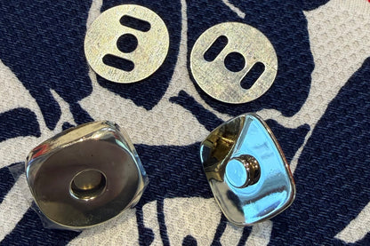 Two parts of snap set on a fabric surface with a floral pattern