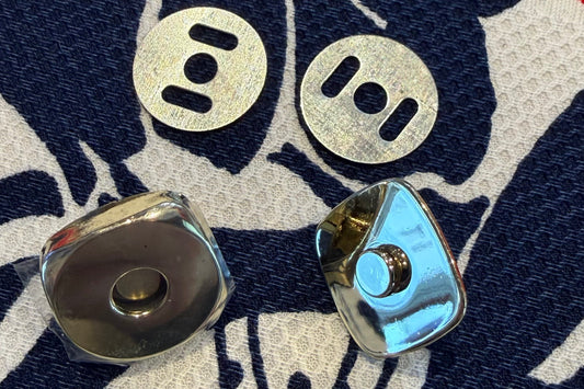 Two parts of snap set on a fabric surface with a floral pattern